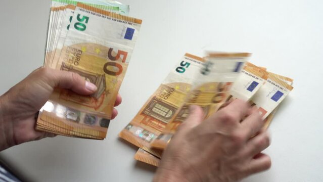 Female hand counting euro banknotes nominated 50.