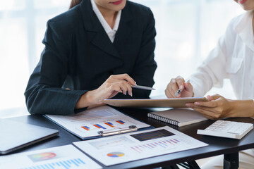 Close-up view of businessman analyzing graphs and organization chart  explain to the meeting the future business trends in the organization.