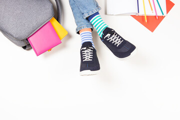 Kid wearing different pair of socks. Child foots in mismatched socks and colorful sneakers,...