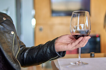 man's hand holding a glass of red wine. visit to a winery in mendoza argentina. Wine tasting. Selective focus