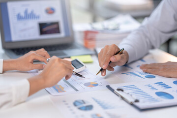 Close-up view of businessman analyzing graphs and organization chart  explain to the meeting the future business trends in the organization.