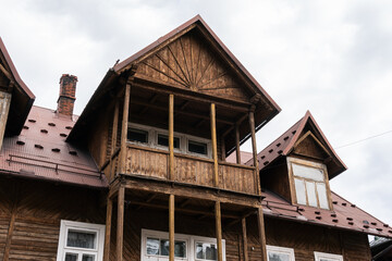 Poland, Rabka-Zdroj  – April 07, 2022: Big wooden house with balcony in vintage and gothic style - obrazy, fototapety, plakaty