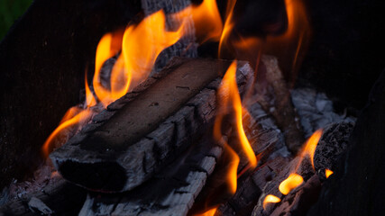 a fire is burning in the barbecue. firewood on the grill in flames