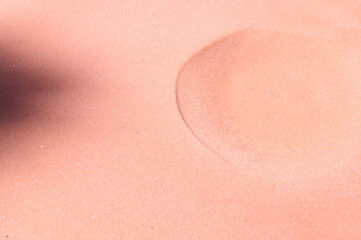 A formed crater on pure pink sand. Sandy background. Copy space for promotional and advertising text