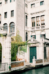 Fototapeta na wymiar Stone facade of an ancient building near the water in Venice