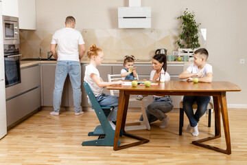 Fototapeta premium young family with three children in the kitchen