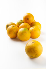 lot of yellow oranges on a white background one in the foreground the rest in the background