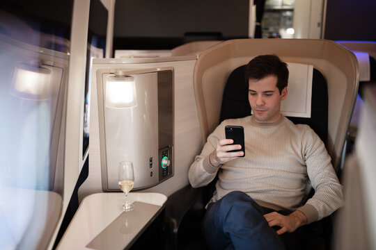 Rich businessman flying first class and working on plane