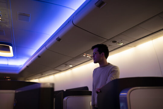 Airline passenger standing in business class cabin on flight