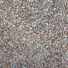 Background of multicolored small stones of white, brown, yellow, gray colors mixed with sand. Tiny...