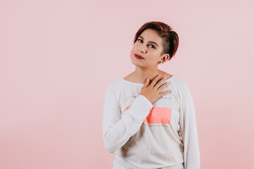 portrait of young hispanic girl posing on coral pink background in Mexico Latin America