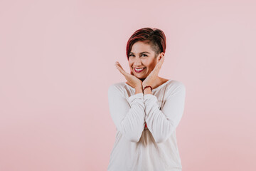 portrait of young hispanic girl posing on coral pink background in Mexico Latin America