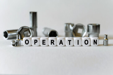 On a white background, a set with tools and white cubes with the inscription - operation