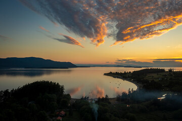 Fototapeta premium Sunset Aerial View of Legoe Bay On Lummi Island, Washington. A beautiful summer evening in the San Juan Islands with Orcas Island and Rosario Strait in the background.