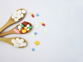 Fototapeta na wymiar Various pharmaceutical medicine pills, tablets and capsules on wooden spoon 