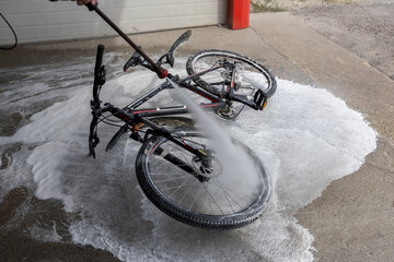 Washed bike. A jet of water under pressure is directed at the bicycle wheel.