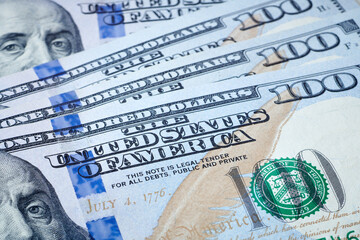 Naklejka premium The united states of america text on hundred dollar bill. Strong global currency in world trade. Center of the global trade. World economic and finance concept. Close up view.