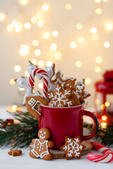 Christmas composition with gingerbread cookies, candy cane and marshmallow in a red mug. Cozy home...