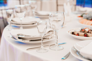 empty wine glasses on a round table with a white tablecloth. 