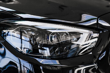 black car headlight. sale of cars. dealership. rent and sale of cars.