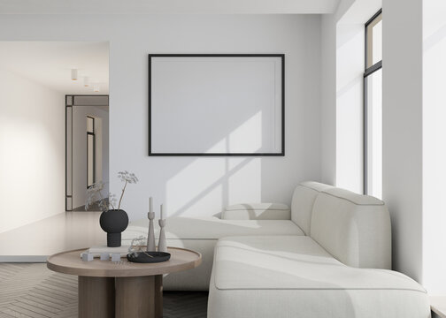 Empty black horizontal picture frame on white wall in modern living room. Mock up interior in contemporary style. Free, copy space for your picture, poster. Sofa, table with vase. 3D rendering.