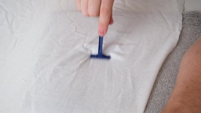 A man removes fabric pills using a disposable shaving machine. A razor for removing pellets.