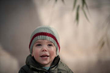 Niño bebé con gorro de lana sonriendo y mirando a la cámara