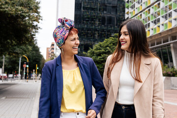 a Latin adult two women laughing on the street