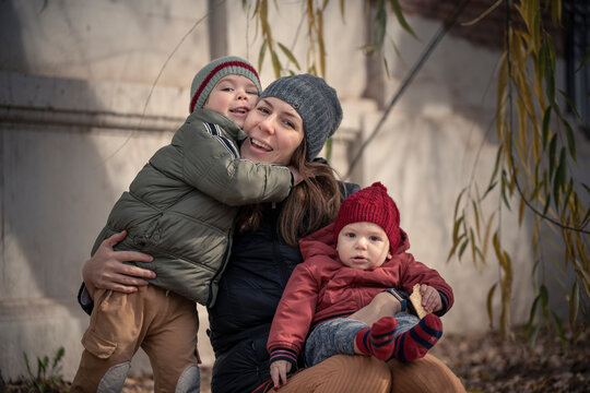 Mam&aacute; con sus hijos beb&eacute; y ni&ntilde;o disfrutando del oto&ntilde;o invierno entre los &aacute;rboles