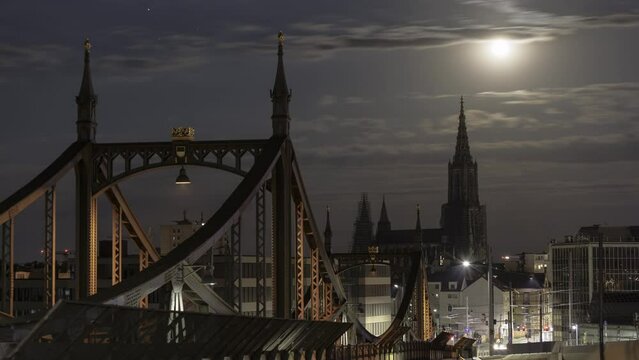 Ulm minster and historic bridge Neutorbr&uuml;cke at night with full moon time lapse