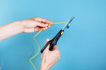 Destroy optical fiber with scissors. Isolated on blue