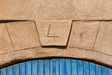 House number '4' is engraved into the limestone over a blue wooden door. Old style french house. 