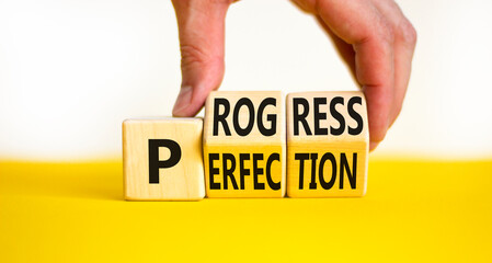 Progress or perfection symbol. Concept words Progress or Perfection on wooden cubes. Businessman hand. Beautiful yellow table white background. Business progress or perfection concept. Copy space.