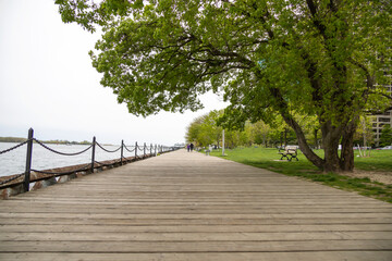 Pedestrians walking on a wooden boardwalk by the ocean