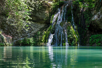Waterfall in The Valley of Butterflies. The Petaloudes valley nature reserve in Rhodes, Greece,...
