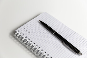 Notepad and pen close-up on the table surface.