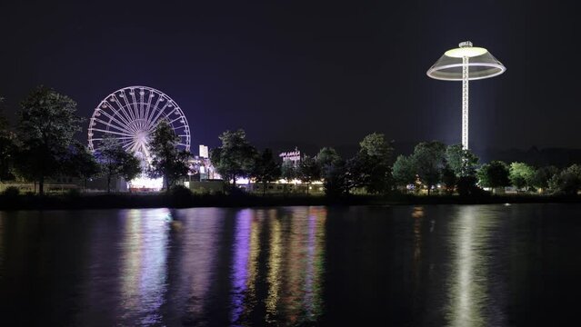 Fair at night with reflection in river time lapse