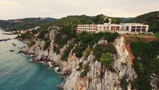 Kassandra Cliffs and a white building seen from bird's eye perspective from the direction of the sea. Cloudy sky. High quality photo