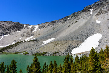 Picturesque Barney Lake surrounded by steep mountain ridge with a small snow patches near Mammoth Lakes, California.