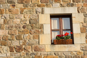 Fototapeta na wymiar Facade with window and flowers in Barcena Mayor, Cantabria 