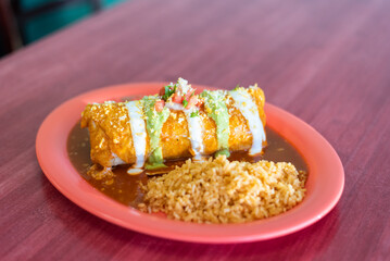 Delicious Mexican food burrito chimichanga on plate with rice and beans