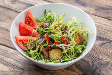 Potato, beef, and vegetable salad on a wooden background, top view. Balanced diets healthy food