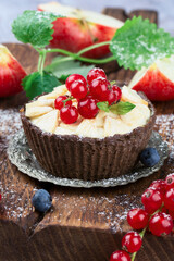 Apple tartlet with cream on a black background. Summer fruit baking. Tartlet with red currant. Top view