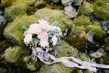 Obraz na płótnie Canvas Bouquet of flowers tied with ribbons lies on a blooming moss