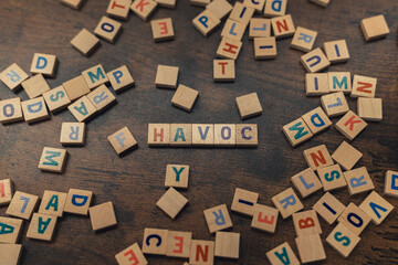 Word play. Square colorful wooden letters creating the word HAVOC. Destruction and demage concept as a symbol. High quality photo