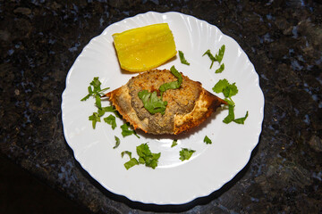Crab cone with typical Brazilian taste with crab meat roasted inside the shell of the crustacean in the white plate with lemon and coriander