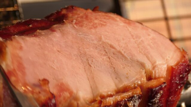 Delicious piece of ham is cut with a knife