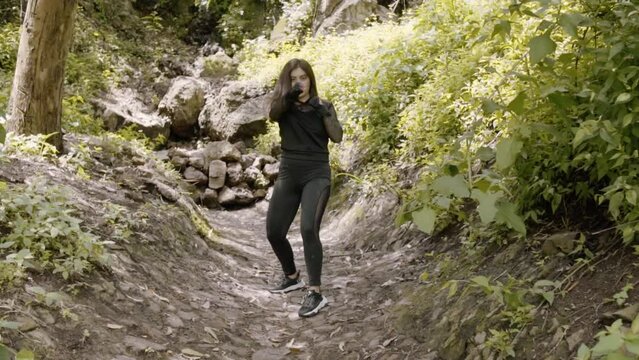 Young woman training box in forest. Mujer joven entrenando box en bosque.
