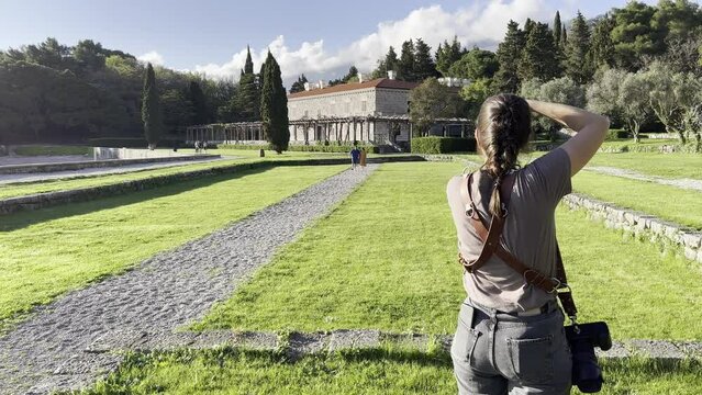 Girl photographer photographs a married couple in the park of Villa Milocer