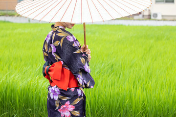 田園のまえに立つ浴衣姿の女性　JAPAN